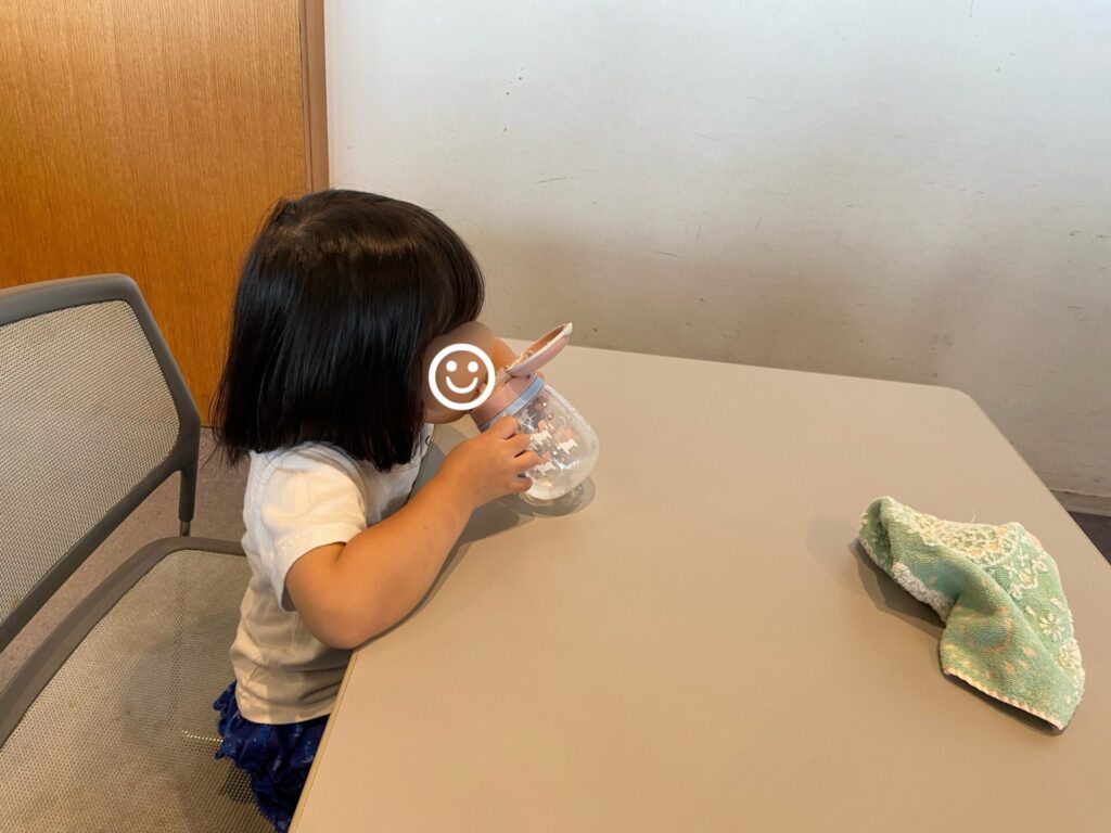 テーブル席で水を飲む子供