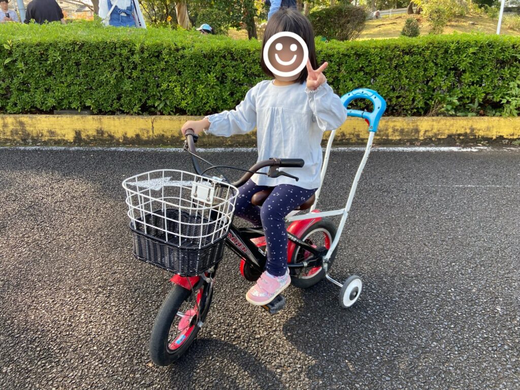 補助輪付き自転車にのる子供