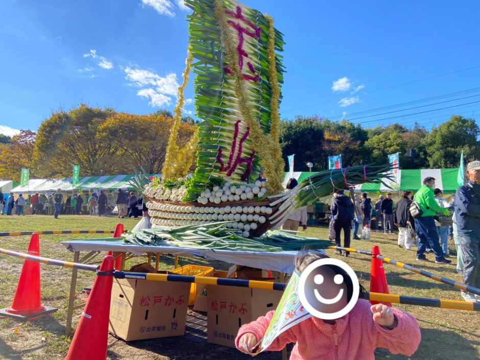 野菜で作られたオブジェの前でピースする子供