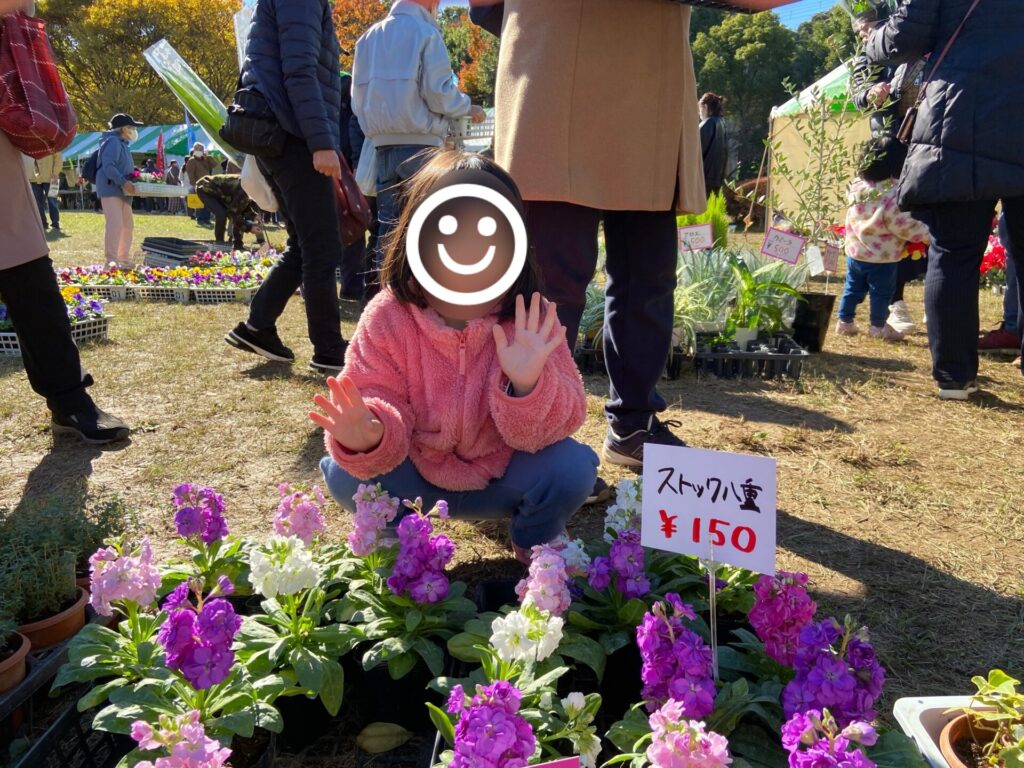 花の苗の前でピースする子供